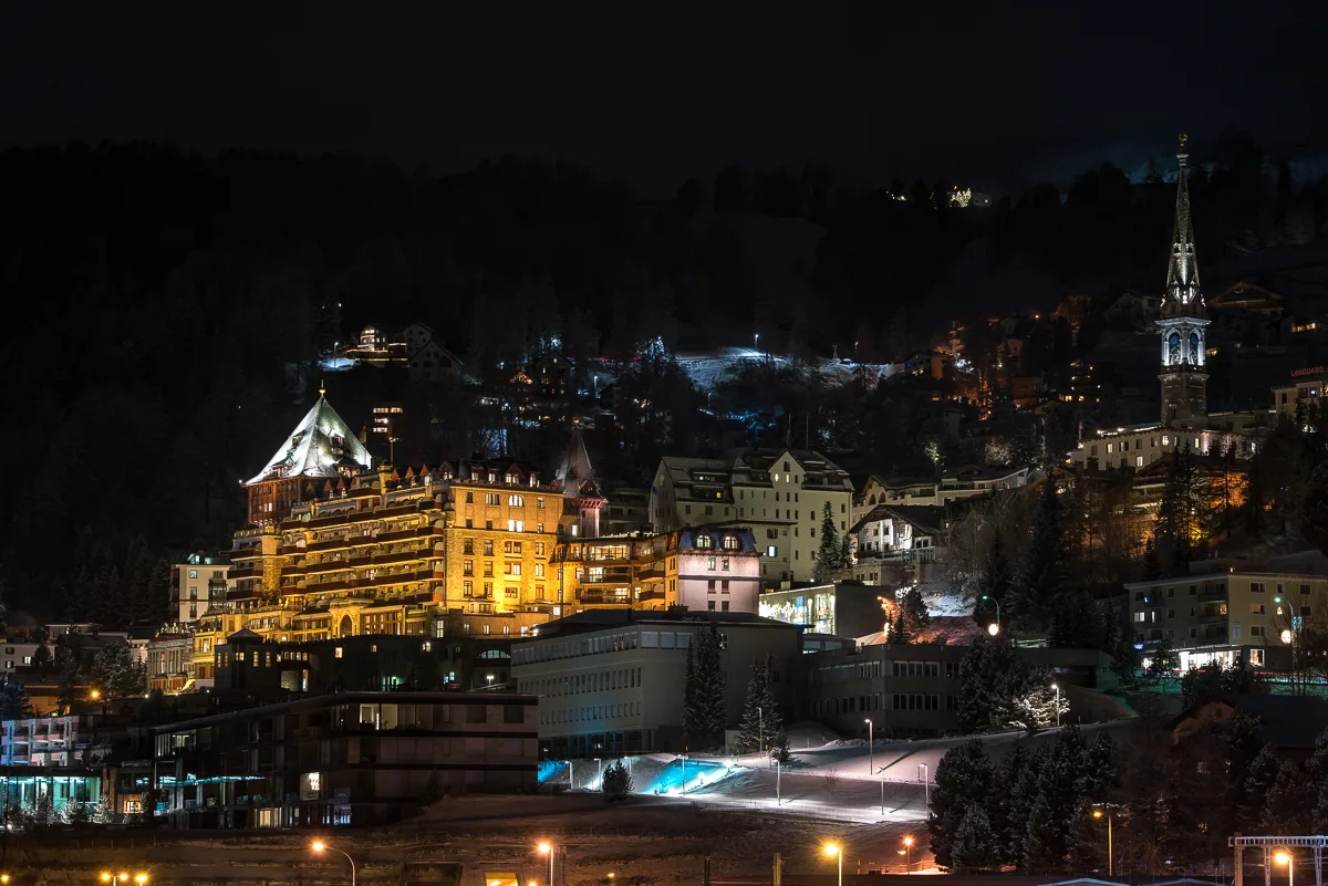 Verschneites St. Moritz mit beleuchteten Hotels an einem Winterabend