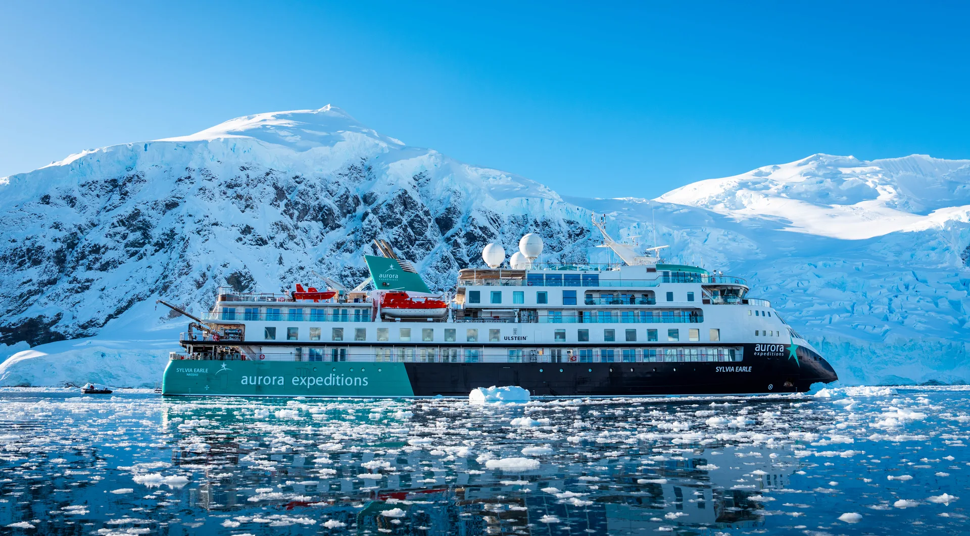 Expeditionsschiff Sylvia Earle vor den verschneiten Bergen von Neko Harbour in der Antarktis