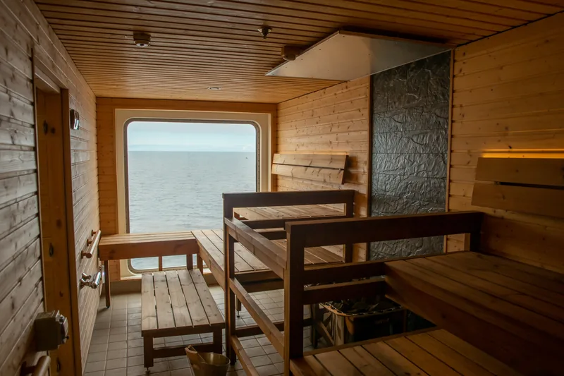 Holzbänke und Fenster mit Meerblick in der Sauna auf der Sylvia Earle