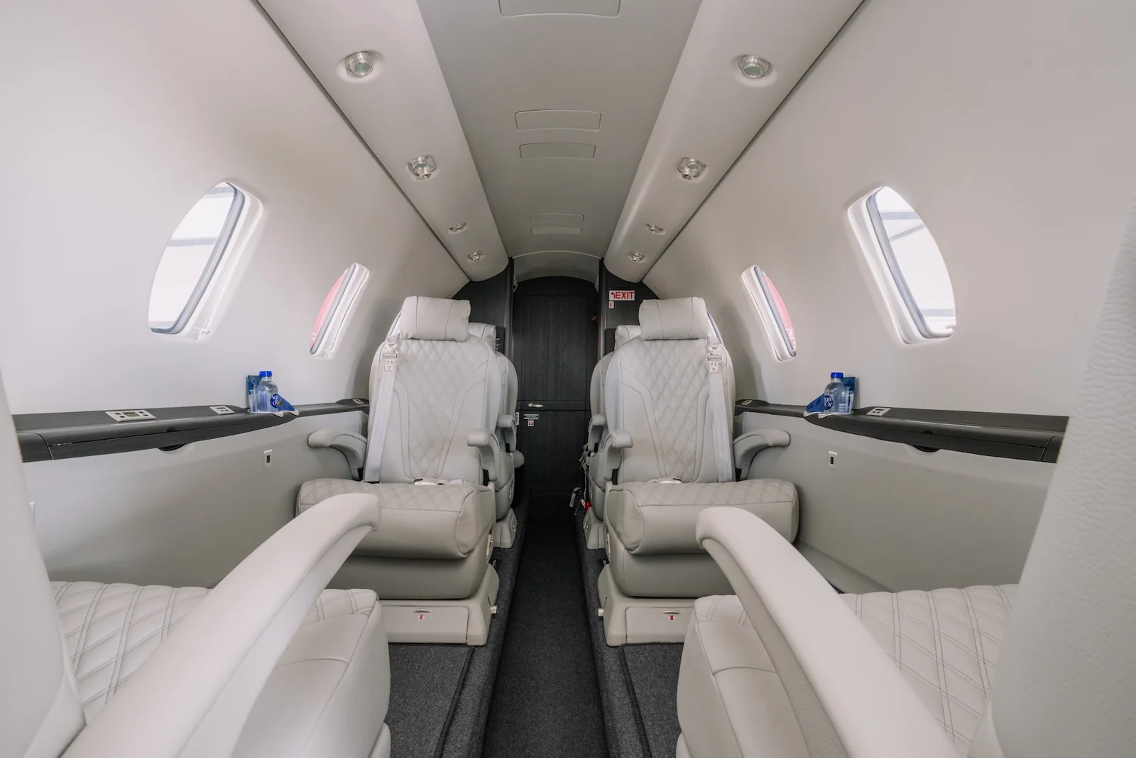 The refurbished Cessna Citation XLS interior, with light diamond-stitched seats, dark surfaces and grey carpet.