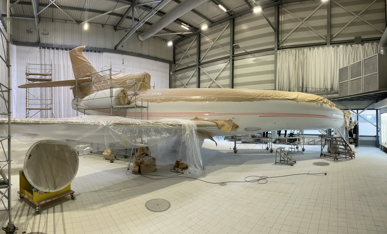 Falcon 7X in the paint shop, masked for painting with the new scheme marked out.
